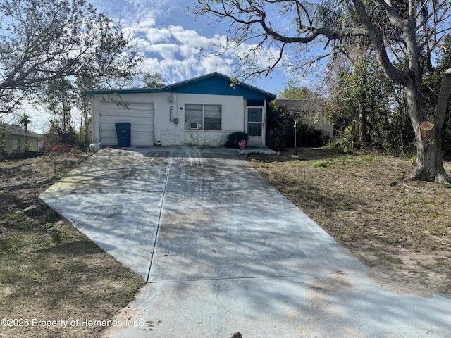 single story home with a garage and concrete driveway