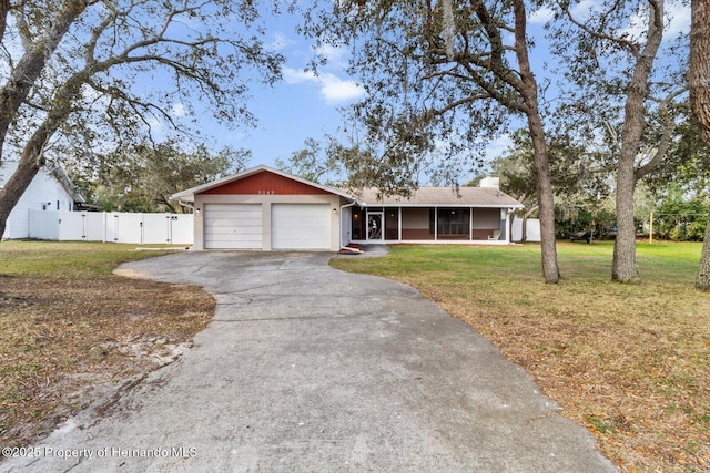 single story home with aphalt driveway, an attached garage, a front yard, a sunroom, and a gate