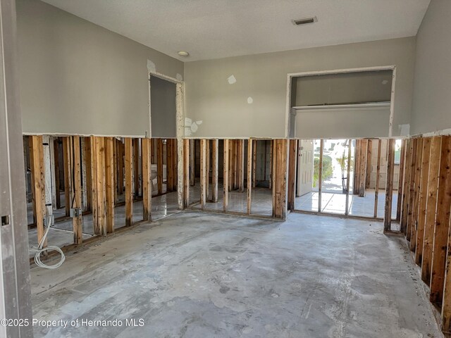 misc room featuring visible vents and unfinished concrete floors