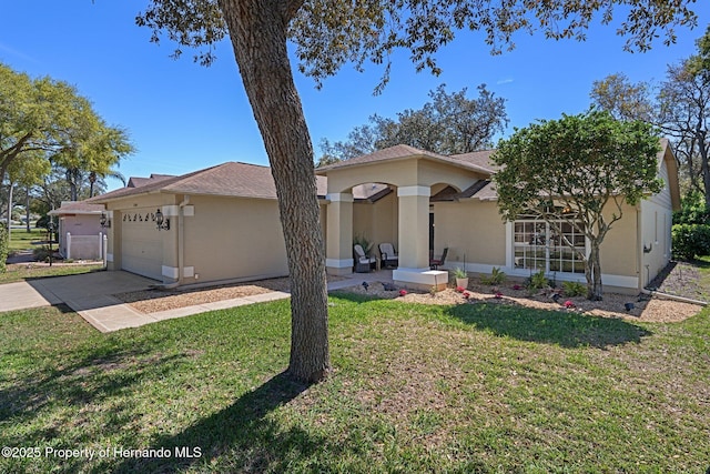 ranch-style house with stucco siding, driveway, a front yard, and a garage