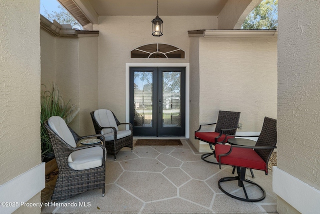 property entrance with stucco siding, french doors, and a patio