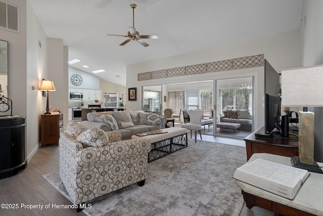 living area featuring visible vents, ceiling fan, high vaulted ceiling, and light wood-style floors