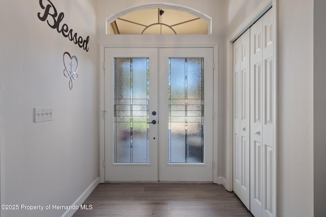 doorway featuring wood finished floors, french doors, and baseboards