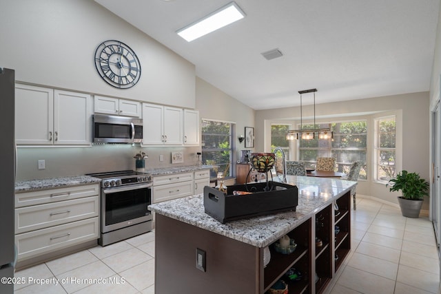 kitchen with white cabinetry, light stone counters, light tile patterned flooring, and stainless steel appliances