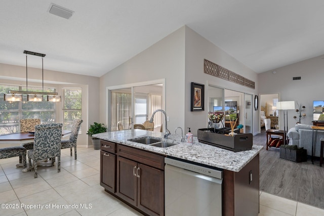 kitchen with visible vents, a sink, light stone counters, open floor plan, and dishwasher