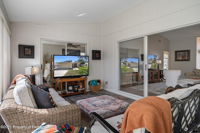 living room featuring vaulted ceiling and stone finish floor