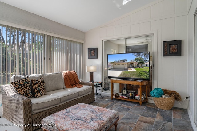 living room with stone tile floors and lofted ceiling