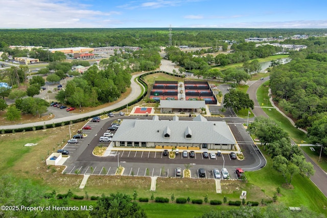 birds eye view of property featuring a forest view and a water view