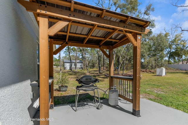 view of patio / terrace with a grill, fence, and an outdoor structure