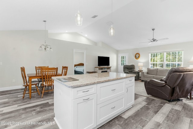 kitchen with hanging light fixtures, white cabinetry, light wood-style flooring, and visible vents