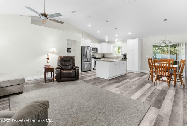 living room with baseboards, light wood finished floors, and a healthy amount of sunlight