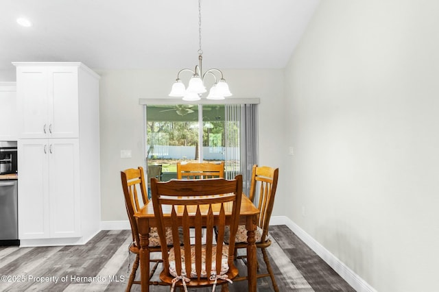 dining room with dark wood-type flooring, a notable chandelier, and baseboards