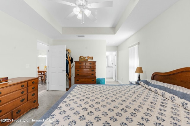 bedroom with visible vents, a raised ceiling, connected bathroom, ceiling fan, and carpet