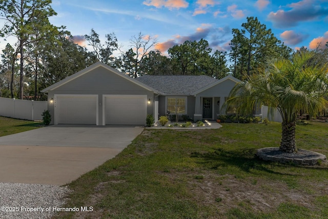 view of front of house with a shingled roof, fence, a garage, driveway, and a front lawn