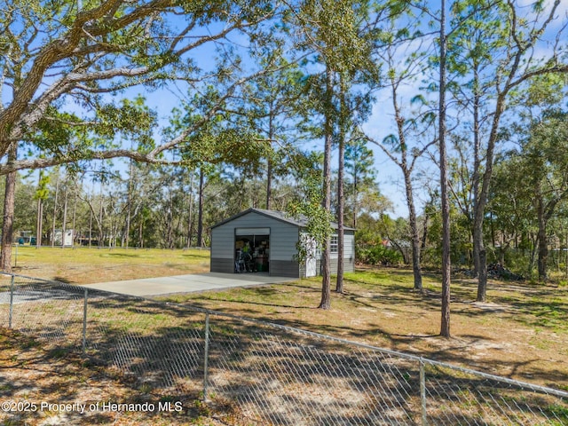 view of yard with driveway, an outdoor structure, and fence