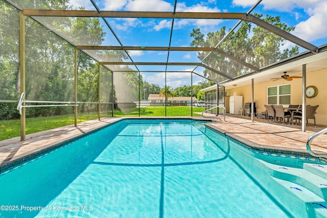 outdoor pool featuring a lanai, ceiling fan, and a patio