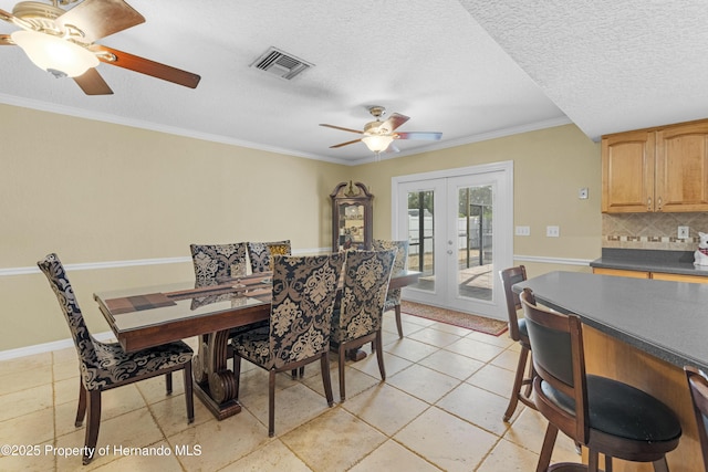 dining room with visible vents, french doors, a textured ceiling, and ornamental molding