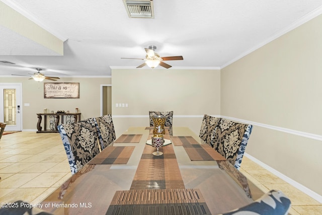 tiled dining space featuring a ceiling fan, baseboards, visible vents, and ornamental molding