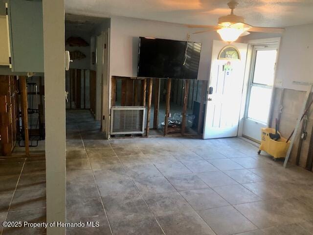 unfurnished living room with a ceiling fan and tile patterned flooring