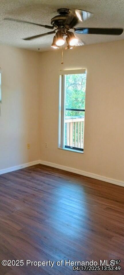12437 Drayton Dr, Spring Hill, FL 34609 - unfurnished room with ceiling fan, dark wood-type flooring, and a textured ceiling