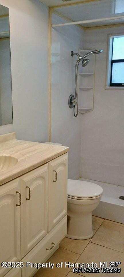 12437 Drayton Dr, Spring Hill, FL 34609 - bathroom featuring vanity, tile patterned flooring, a shower stall, and toilet