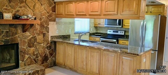 12437 Drayton Dr, Spring Hill, FL 34609 - kitchen with a peninsula, a sink, dark stone countertops, and appliances with stainless steel finishes