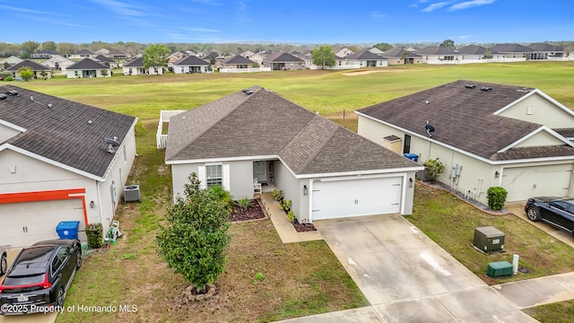 view of front of home featuring a residential view, an attached garage, concrete driveway, and roof with shingles