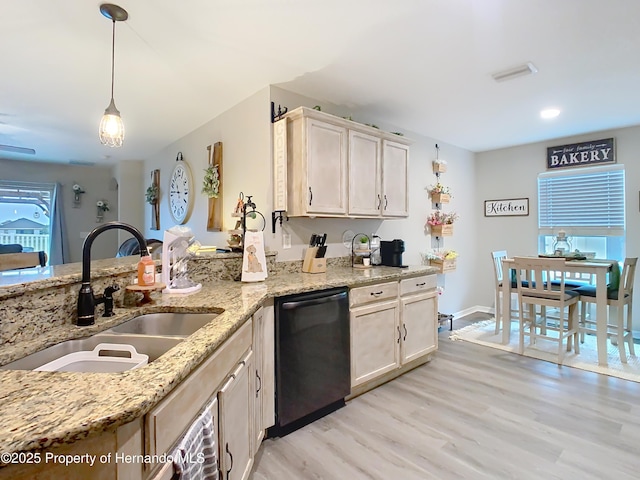 kitchen featuring light wood-type flooring, a sink, light stone counters, black dishwasher, and hanging light fixtures