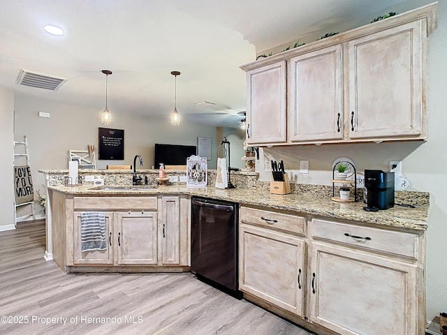 kitchen featuring visible vents, a peninsula, a sink, light wood-style floors, and dishwasher