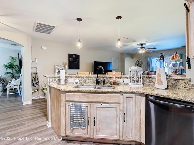 kitchen with visible vents, a sink, light stone counters, arched walkways, and dishwasher