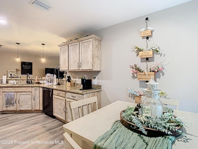 kitchen with visible vents, decorative light fixtures, black dishwasher, a peninsula, and light wood-style floors