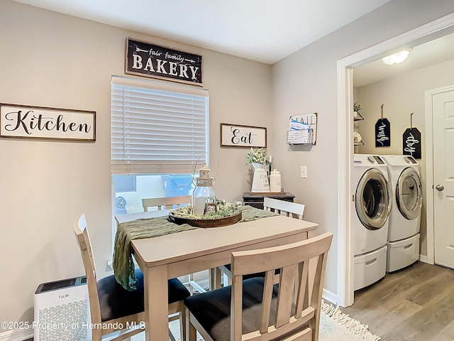 washroom with light wood-type flooring, washing machine and dryer, and laundry area