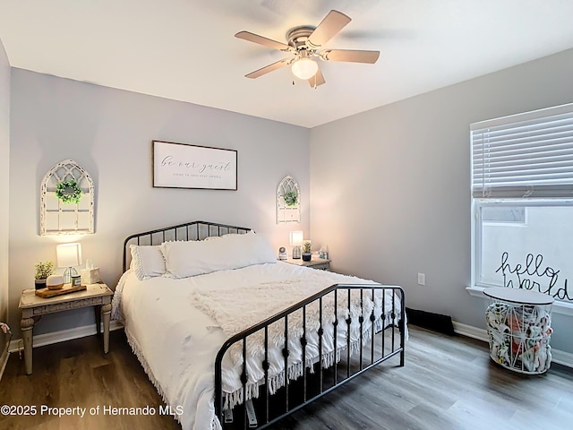 bedroom featuring wood finished floors, baseboards, and ceiling fan