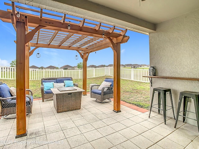 view of patio featuring outdoor dry bar, a pergola, an outdoor living space, a fenced backyard, and a residential view