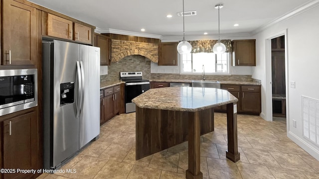 kitchen with visible vents, a sink, light stone counters, stainless steel appliances, and a breakfast bar area