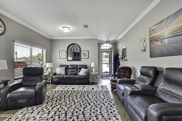 living room featuring a wealth of natural light, visible vents, and wood finished floors