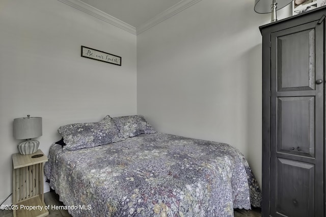 bedroom featuring wood finished floors and ornamental molding