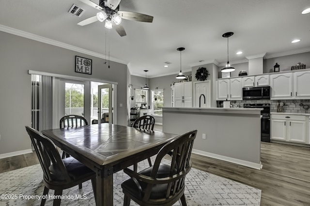 dining area featuring visible vents, recessed lighting, crown molding, and wood finished floors