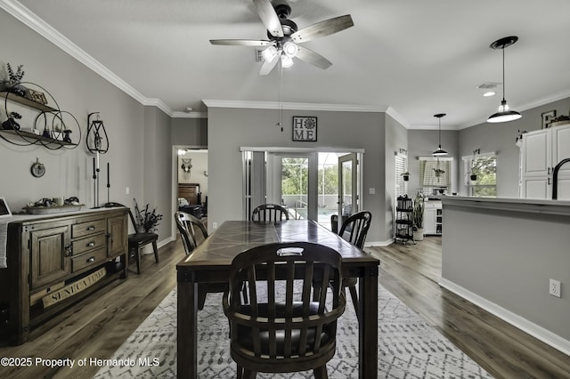 dining space with wood finished floors, baseboards, and ornamental molding