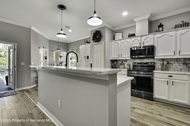 kitchen with visible vents, decorative backsplash, white cabinets, light wood-style floors, and appliances with stainless steel finishes