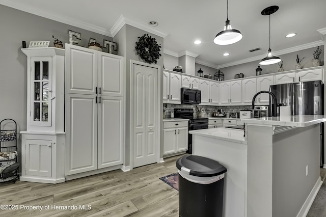 kitchen featuring white cabinetry, black appliances, and visible vents