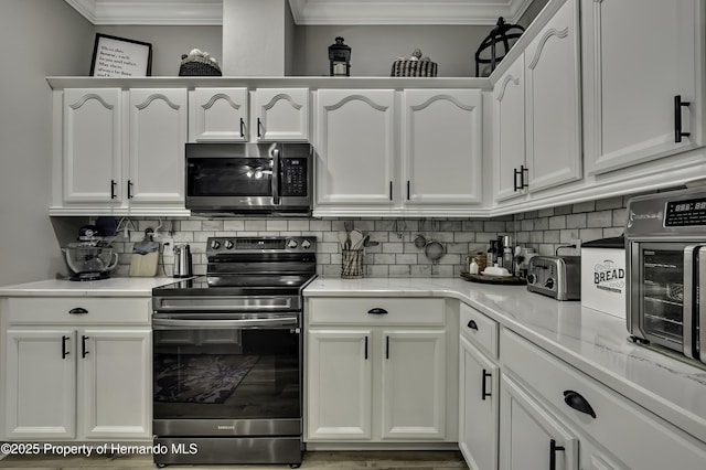 kitchen with white cabinetry, backsplash, and stainless steel appliances