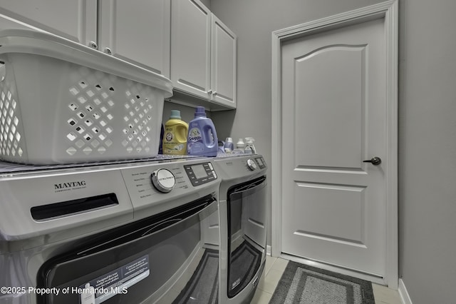 clothes washing area featuring cabinet space, light tile patterned floors, and separate washer and dryer