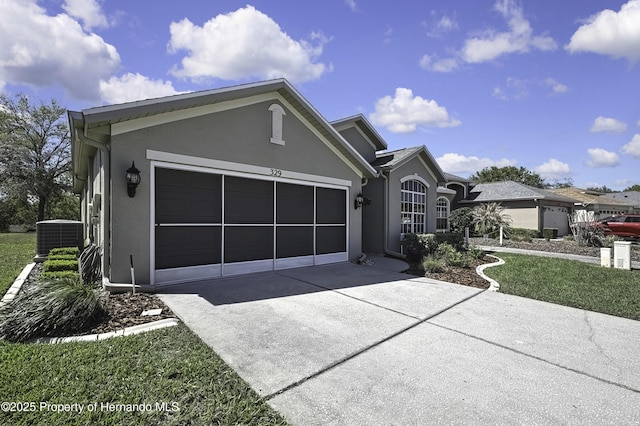 view of front of home with central air condition unit, a garage, driveway, and stucco siding