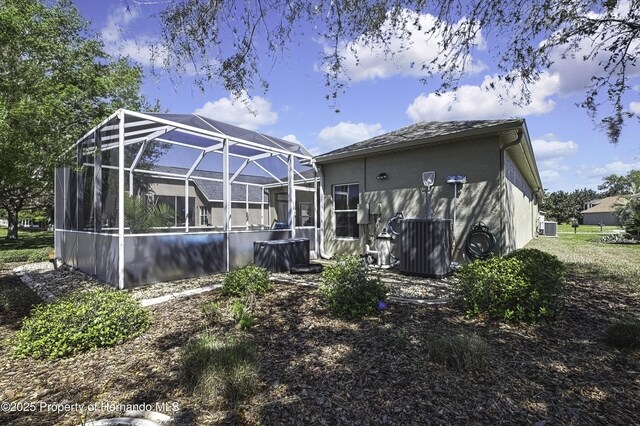 rear view of property with a lanai and stucco siding