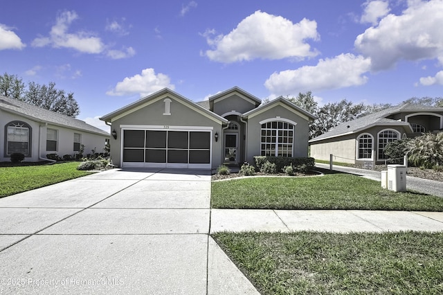 ranch-style home featuring stucco siding, a garage, concrete driveway, and a front lawn