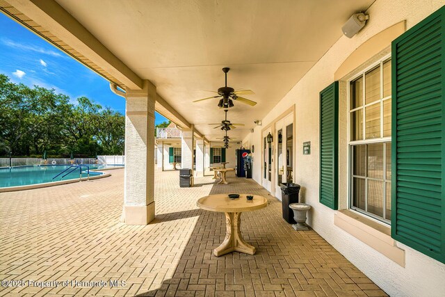 view of patio featuring french doors, fence, a ceiling fan, and a community pool