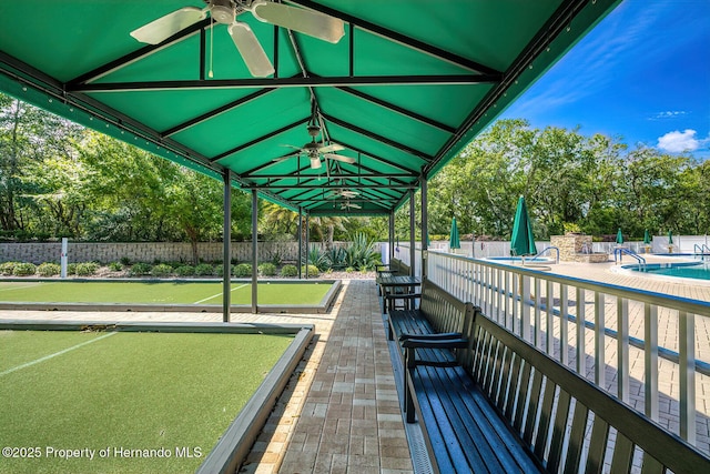 view of property's community with a pool and fence