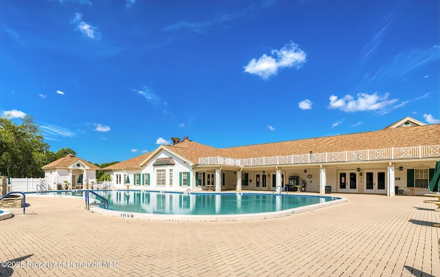 pool featuring french doors, a patio, and fence