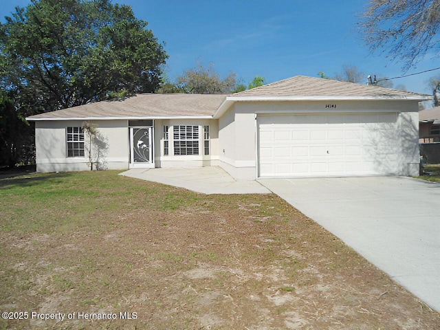 ranch-style home featuring concrete driveway, an attached garage, a front yard, and stucco siding